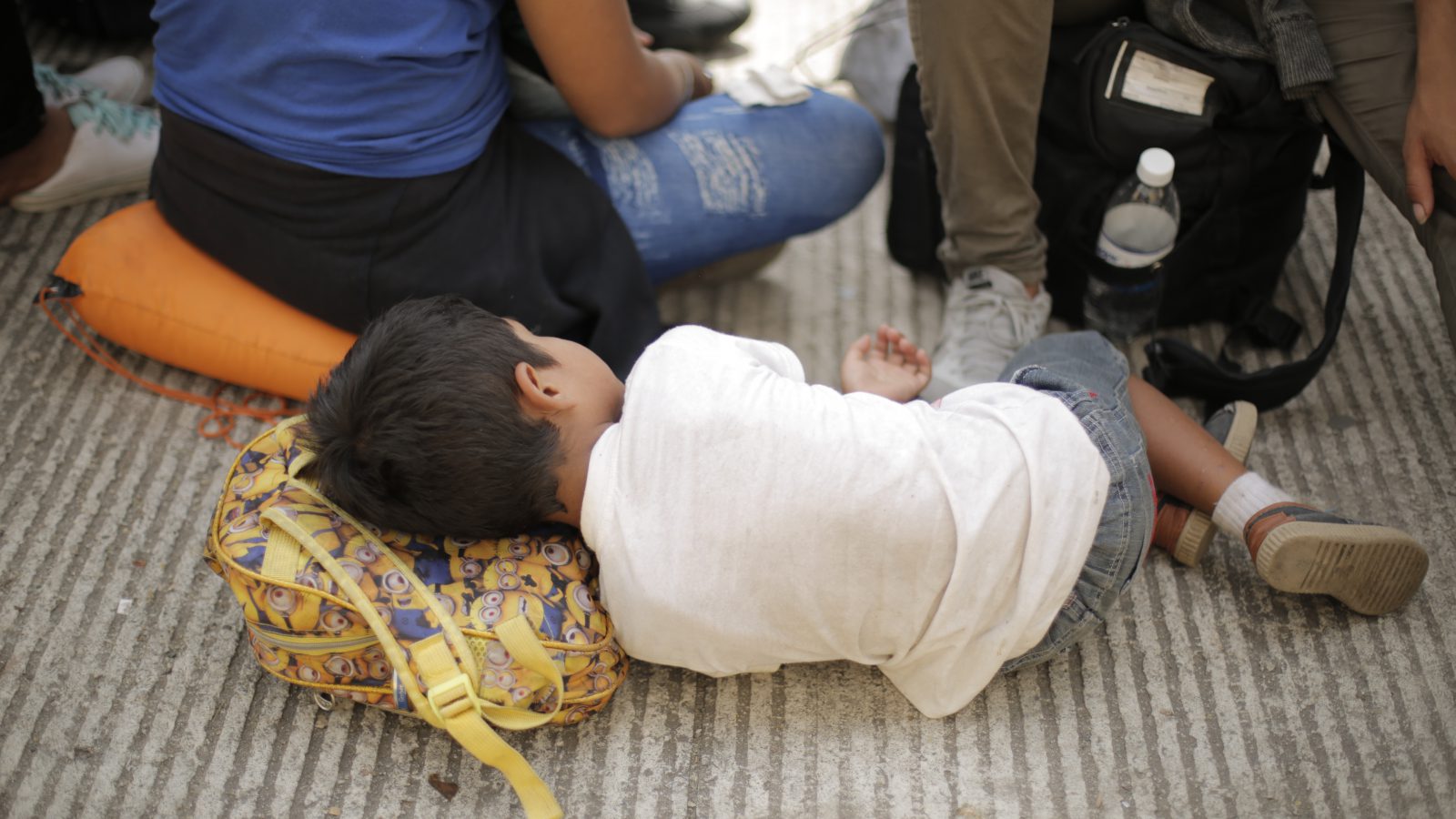 A child rests among a crowd of asylum-seekers outside an immigration office on the outskirts of Mexico City. In the last few years, an unprecedented number of unaccompanied children have been fleeing from gang violence in Central America. Many are arriving at the U.S. southern border alone, scared and seeking refuge.